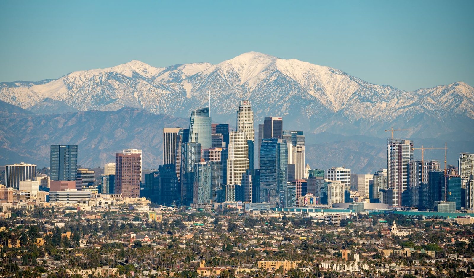 The downtown Los Angeles, California skyline with the snow-capped San Gabriel Mountains behind it